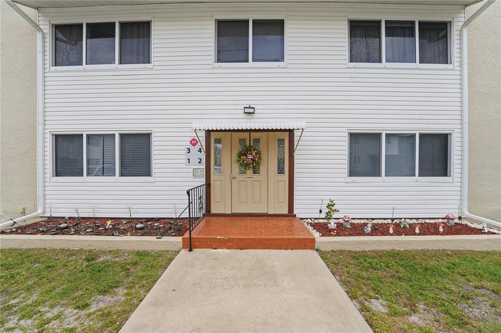 A two-story white building features a central entrance with a wreath and unit numbers — 22481 WESTCHESTER BOULEVARD UNIT A3, PUNTA GORDA, FL