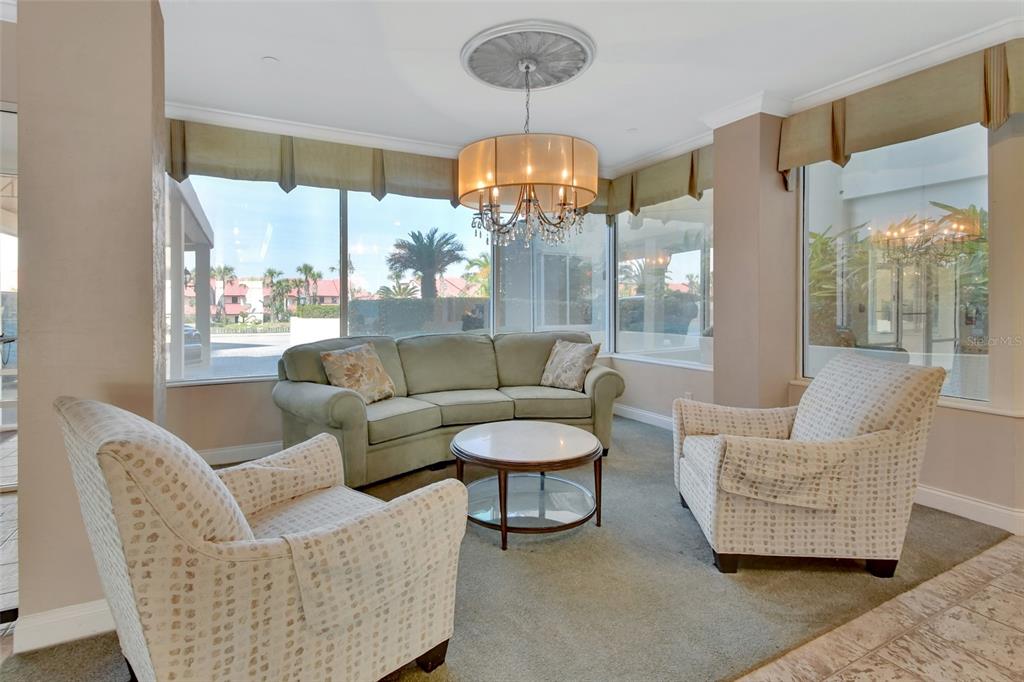 A living area features a green sofa, two patterned armchairs, and a central chandelier — 2937 S ATLANTIC AVENUE UNIT 2009, DAYTONA BEACH SHORES, FL