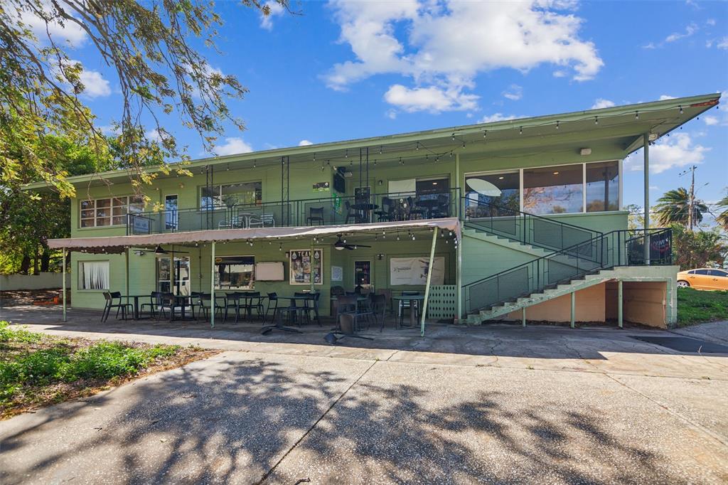 A two-story green commercial building with an outdoor patio, balcony, and exterior staircase — 1200 8TH AVENUE SW UNIT 1, LARGO, FL