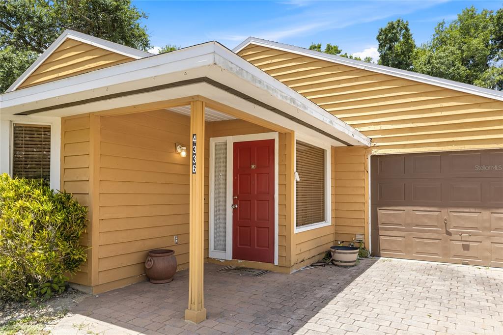 A single-story house with yellow siding, a red front door, and a paved driveway — 4336 CACTUS AVENUE, SARASOTA, FL