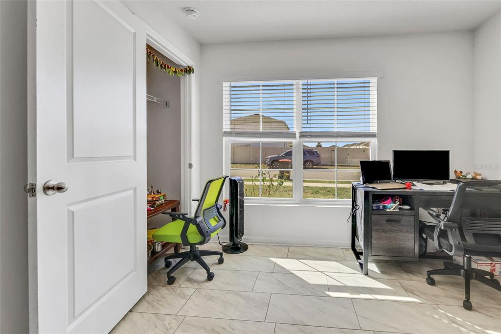 A home office with tile flooring, a desk, and a window overlooking a street — 8640 SW 49TH CIRCLE, OCALA, FL