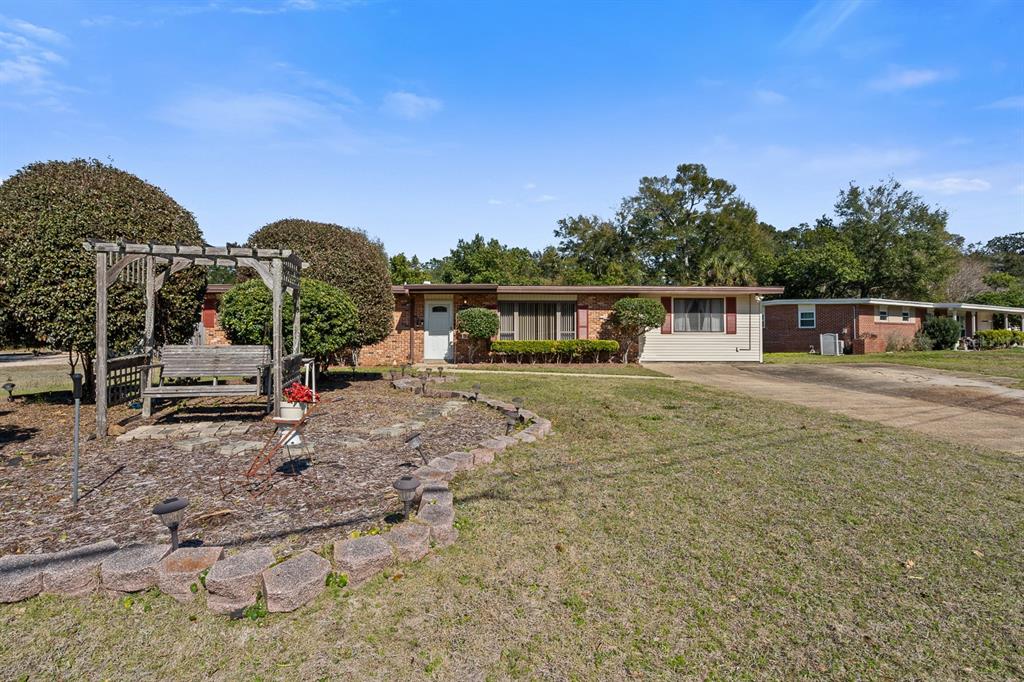 A single-story brick house features a wooden pergola with a swing in the front yard — 3808 SAN GABRIEL DRIVE, PENSACOLA, FL