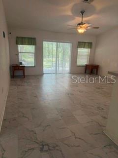 A living room features light-colored tile flooring, a ceiling fan, and sliding glass doors — 3010 GREYNOLDS AVENUE, SPRING HILL, FL