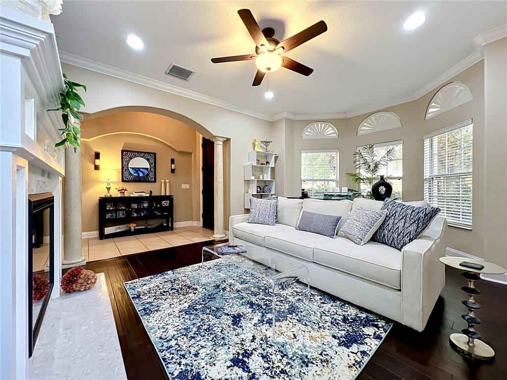 A tiled entryway leads into a living room with dark wood floors and a white sofa — 6977 DOLCE STREET, ORLANDO, FL