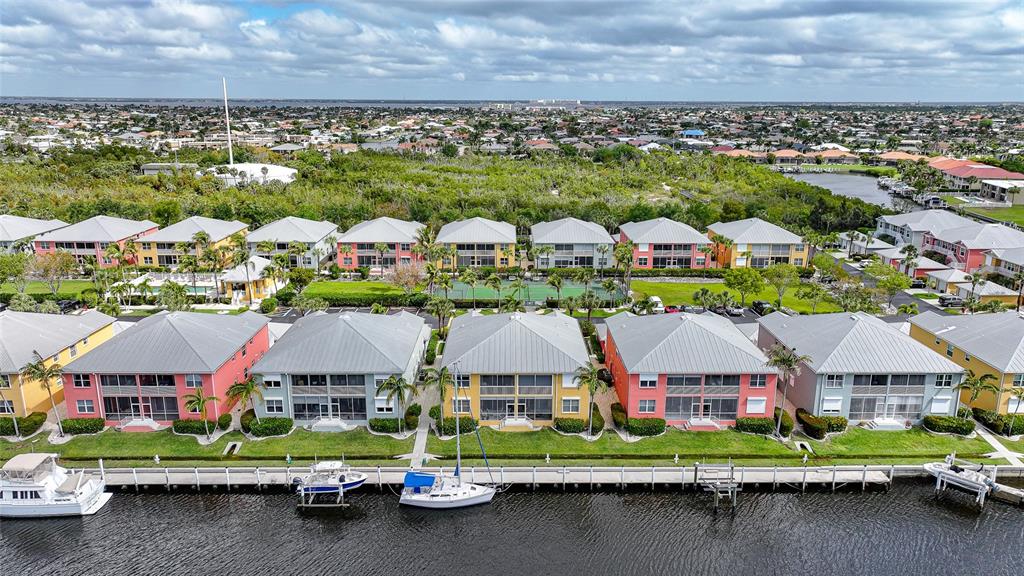 An aerial view shows a row of colorful waterfront townhouses with boat slips along a canal — 2002 BAL HARBOR BOULEVARD UNIT 1822, PUNTA GORDA, FL