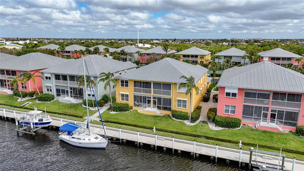 An aerial view shows colorful multi-story waterfront townhomes with boat docks along a canal — 2002 BAL HARBOR BOULEVARD UNIT 1822, PUNTA GORDA, FL