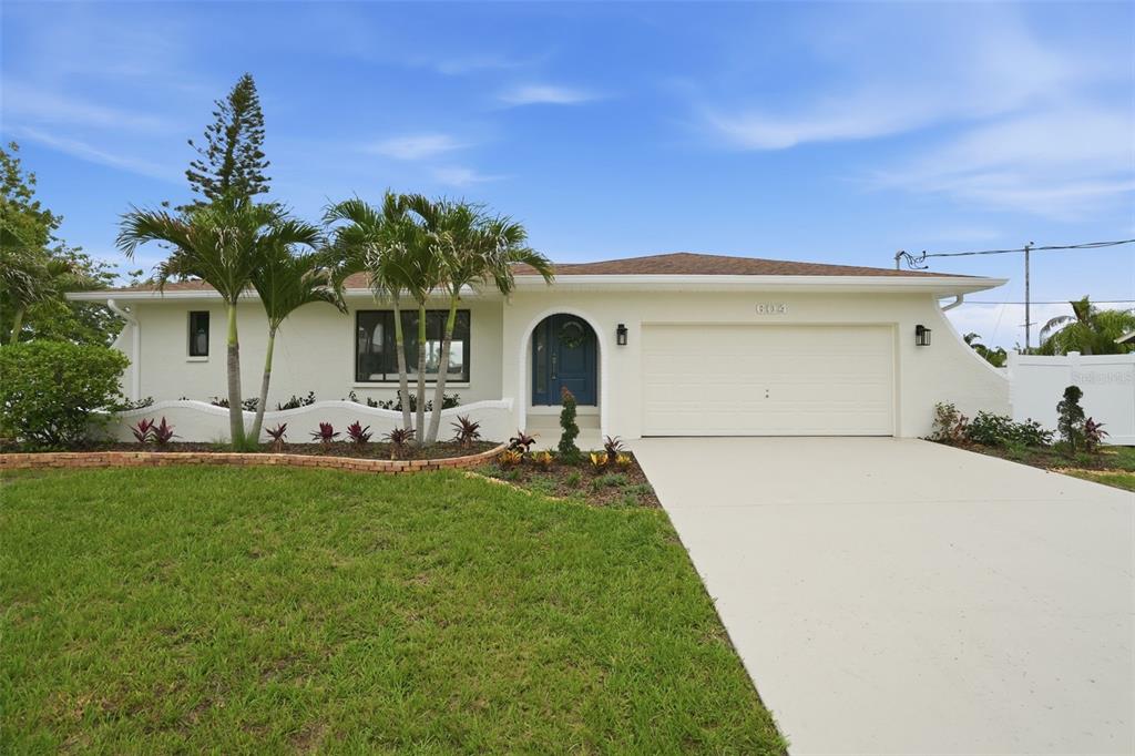 A single-story house with a white exterior, a two-car garage, and a landscaped front yard — 604 KINGSTON COURT, APOLLO BEACH, FL