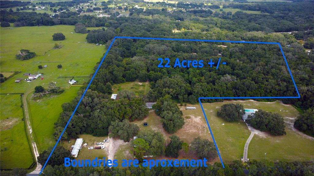 An aerial view shows a large, wooded plot of land with a house and pool — 17281 SE 130TH, WEIRSDALE, FL