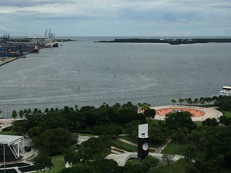 An elevated view of a park, a circular plaza, and a harbor with shipping cranes — MIAMI, FL
