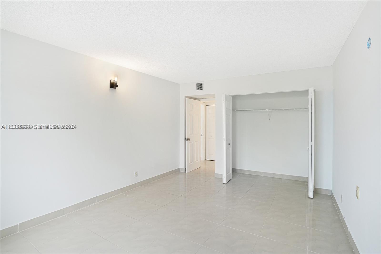 This room features light-colored tile flooring, white walls, a closet, and a doorway — 3800 S Ocean Dr # 414, Hollywood FL 33019, HOLLYWOOD, FL