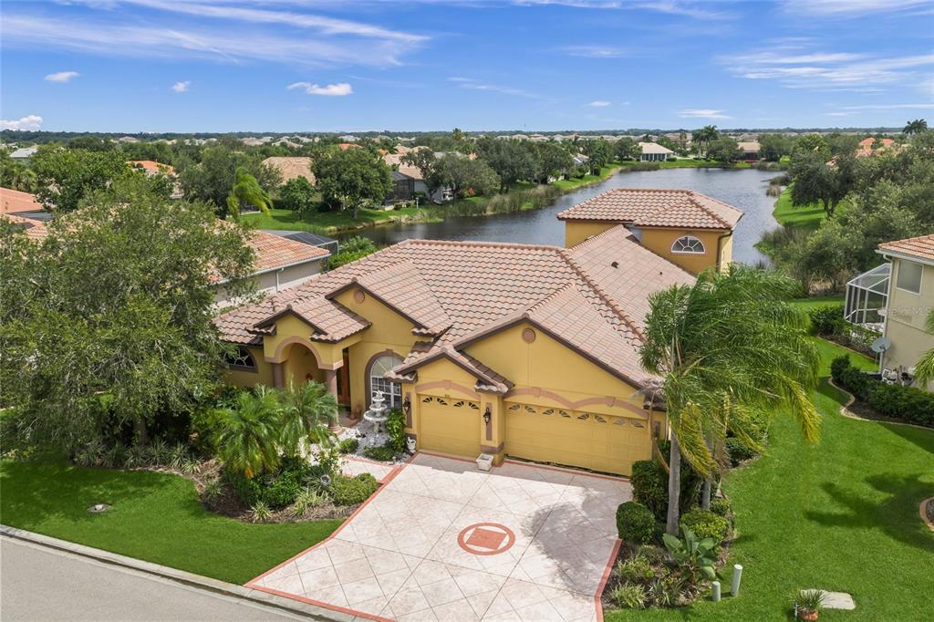 A screened-in swimming pool with a rock waterfall feature and patio seating — 8214 BARTON FARMS BOULEVARD, SARASOTA, FL