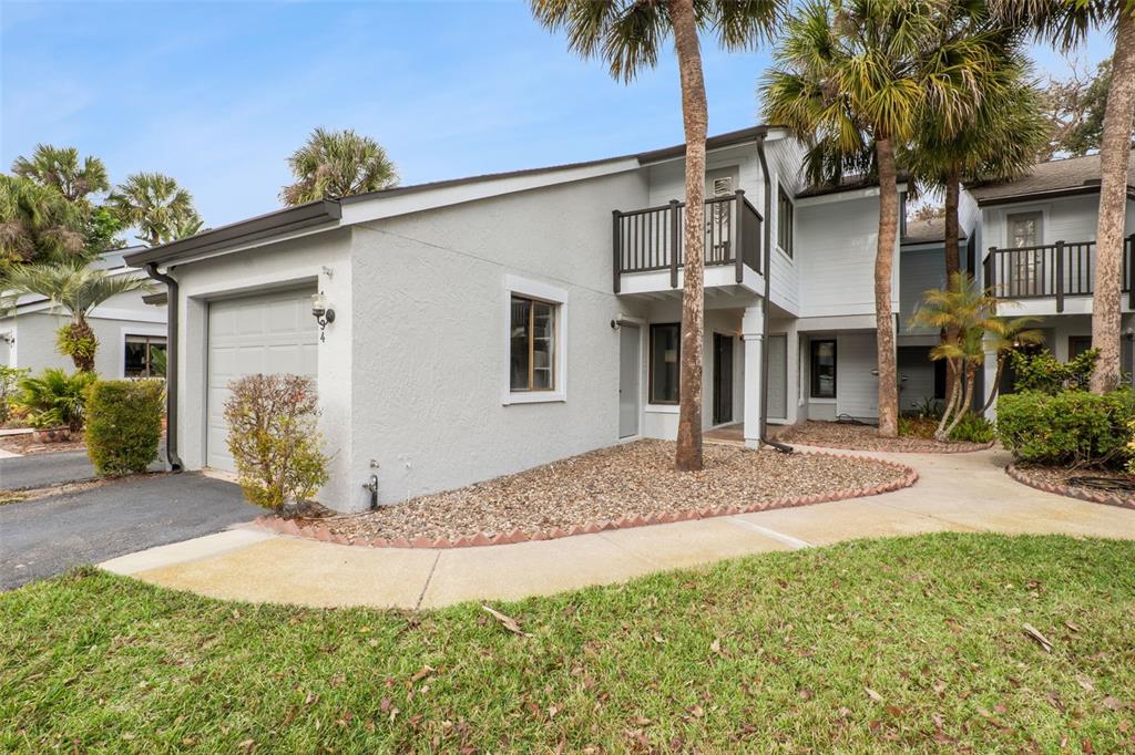 A two-story residential building with a garage, a balcony, and a gravel front yard — 1994 KENASTON ROAD UNIT 1994, MAITLAND, FL