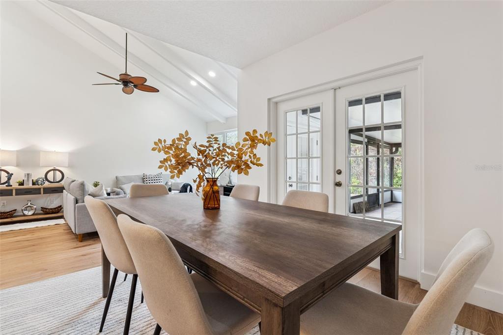 A dining room with a wooden table and chairs leads to a screened-in porch — 1994 KENASTON ROAD UNIT 1994, MAITLAND, FL