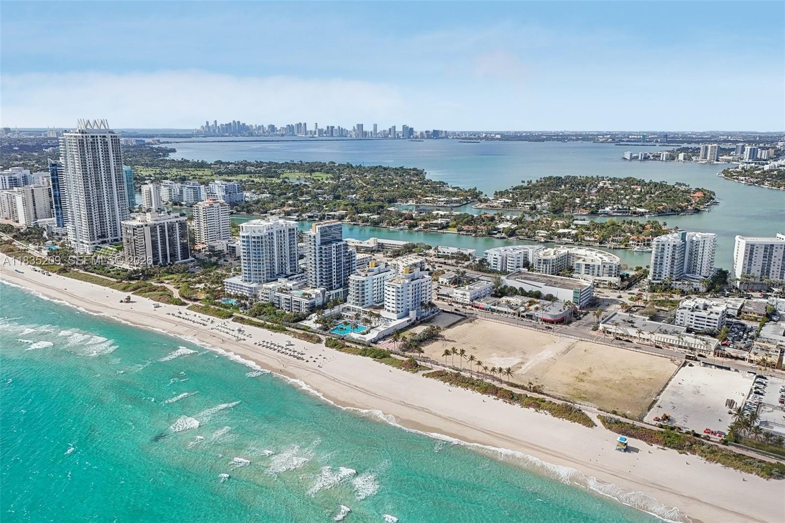 An aerial view of a coastal city featuring high-rise buildings, a sandy beach, and ocean — 6620 Indian Creek Dr # 607, Miami FL 33141, MIAMI, FL