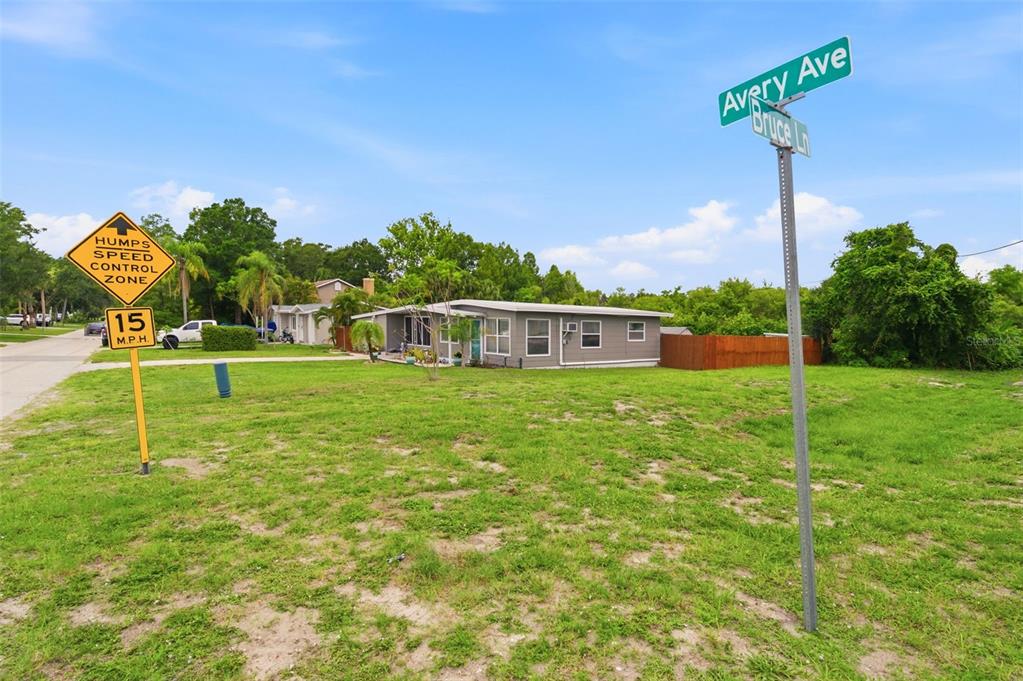 A single-story house with a gray exterior, a teal front door, and a large front lawn — 100 AVERY AVENUE, CRYSTAL BEACH, FL