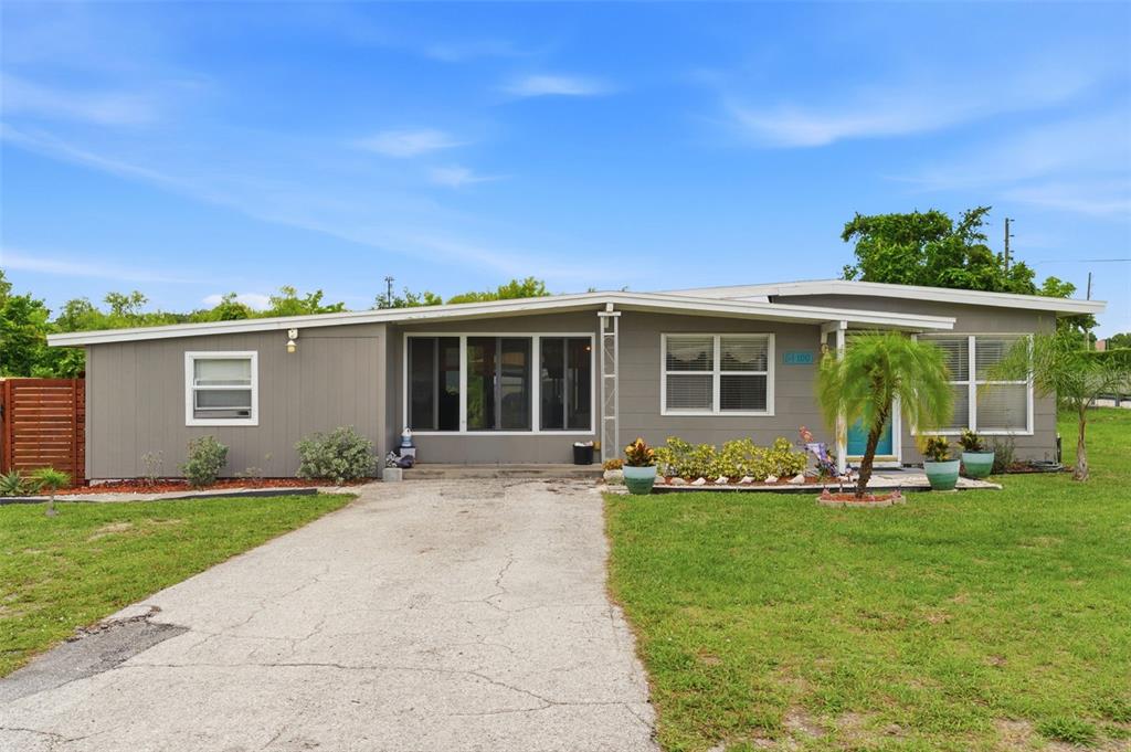 A single-story house sits behind a grassy lot near a street sign and speed bump — 100 AVERY AVENUE, CRYSTAL BEACH, FL