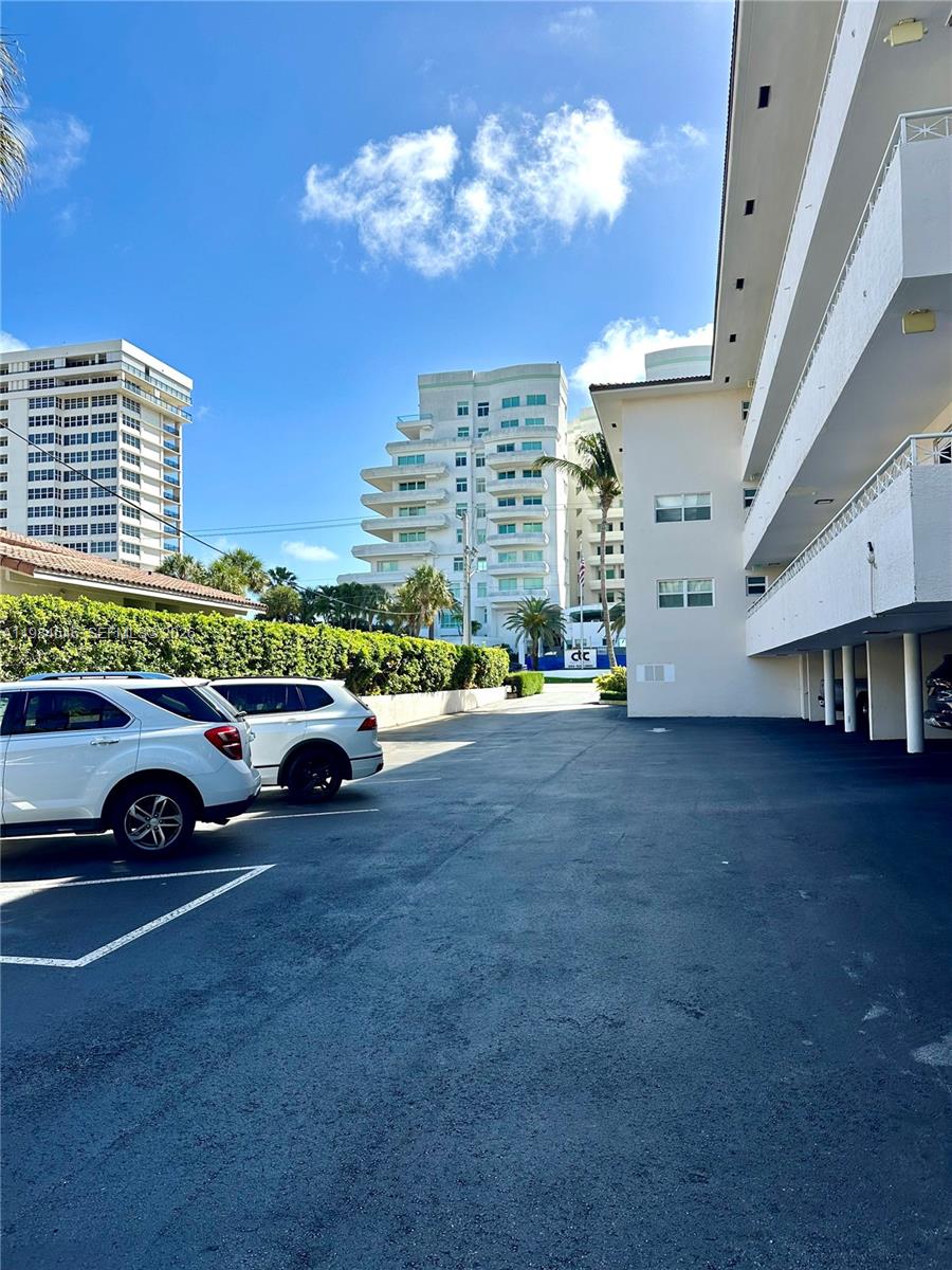 A parking lot sits between a multi-story apartment building and a covered walkway — 2501 S Ocean Blvd # 1040, Boca Raton FL 33432, BOCA RATON, FL