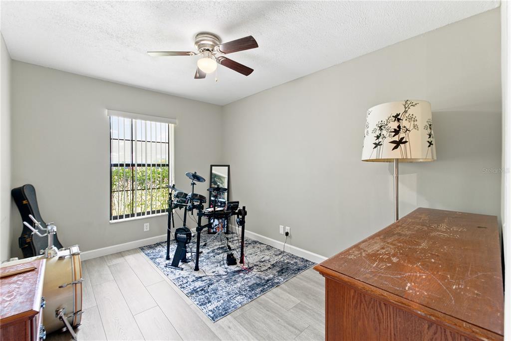 A kitchen features white cabinets, stainless steel appliances, dark countertops, and light wood-look flooring — 3944 NE 7TH STREET, OCALA, FL