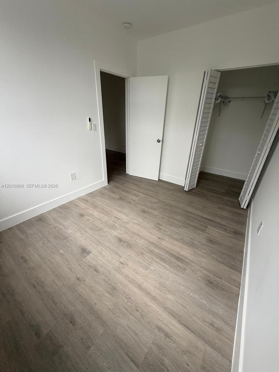 This bedroom features light wood-look flooring, white walls, a closet, and an open doorway — 2330 NW 9 St # 15, Miami FL 33125, MIAMI, FL