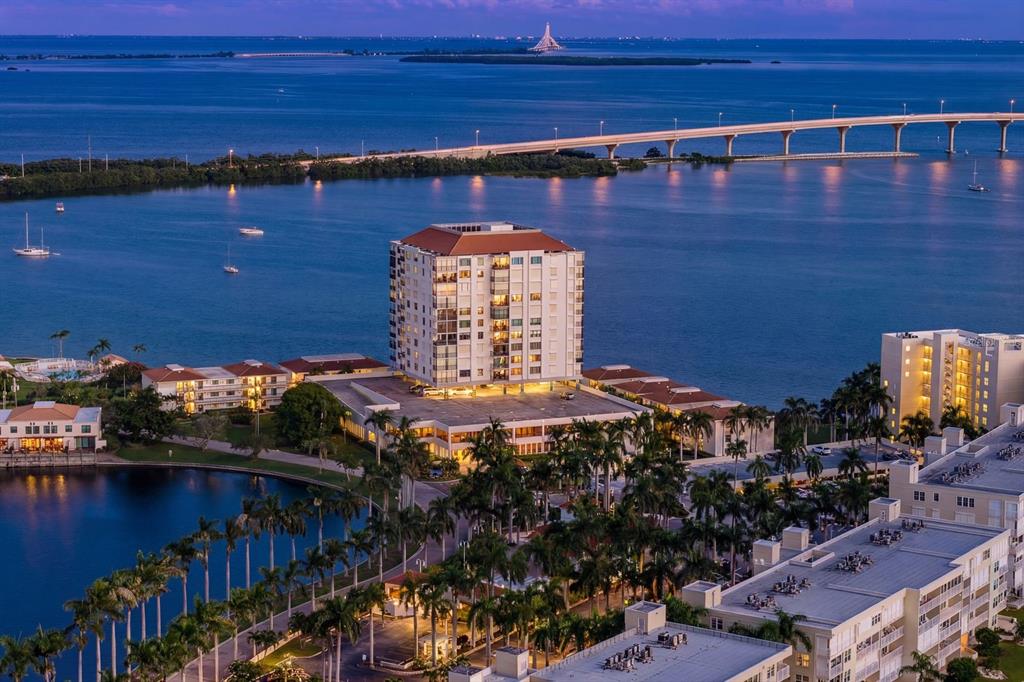 An aerial view of a multi-story apartment building situated on a waterfront near a bridge — 6287 BAHIA DEL MAR CIRCLE UNIT 1202, ST PETERSBURG, FL