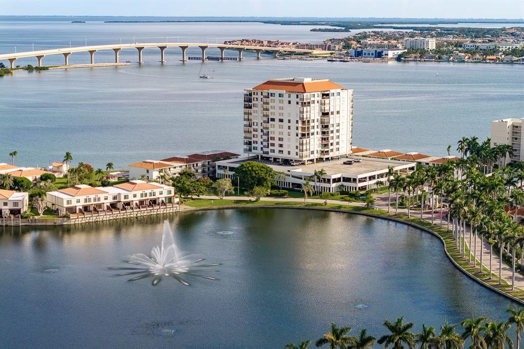 An aerial view of a waterfront condominium complex featuring a fountain and a nearby bridge — 6287 BAHIA DEL MAR CIRCLE UNIT 1202, ST PETERSBURG, FL