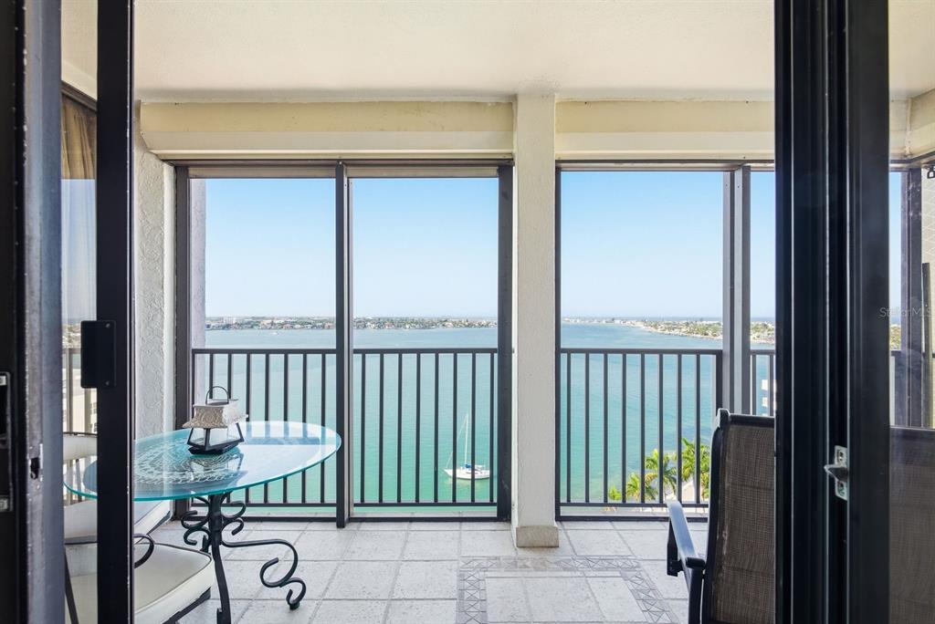 A balcony with tile flooring, a glass table, and a view of the water — 6287 BAHIA DEL MAR CIRCLE UNIT 1202, ST PETERSBURG, FL