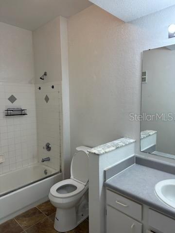 A bathroom features a white toilet, a bathtub with a showerhead, and a vanity with a mirror — 827 CAMARGO WAY UNIT 307, ALTAMONTE SPRINGS, FL