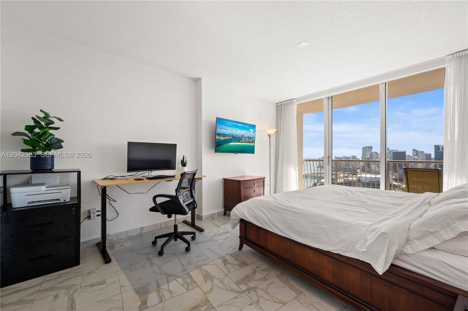 A bedroom features a desk, a bed, and a balcony with a city and water view — 1750 N Bayshore Dr # 5212, Miami FL 33132, MIAMI, FL