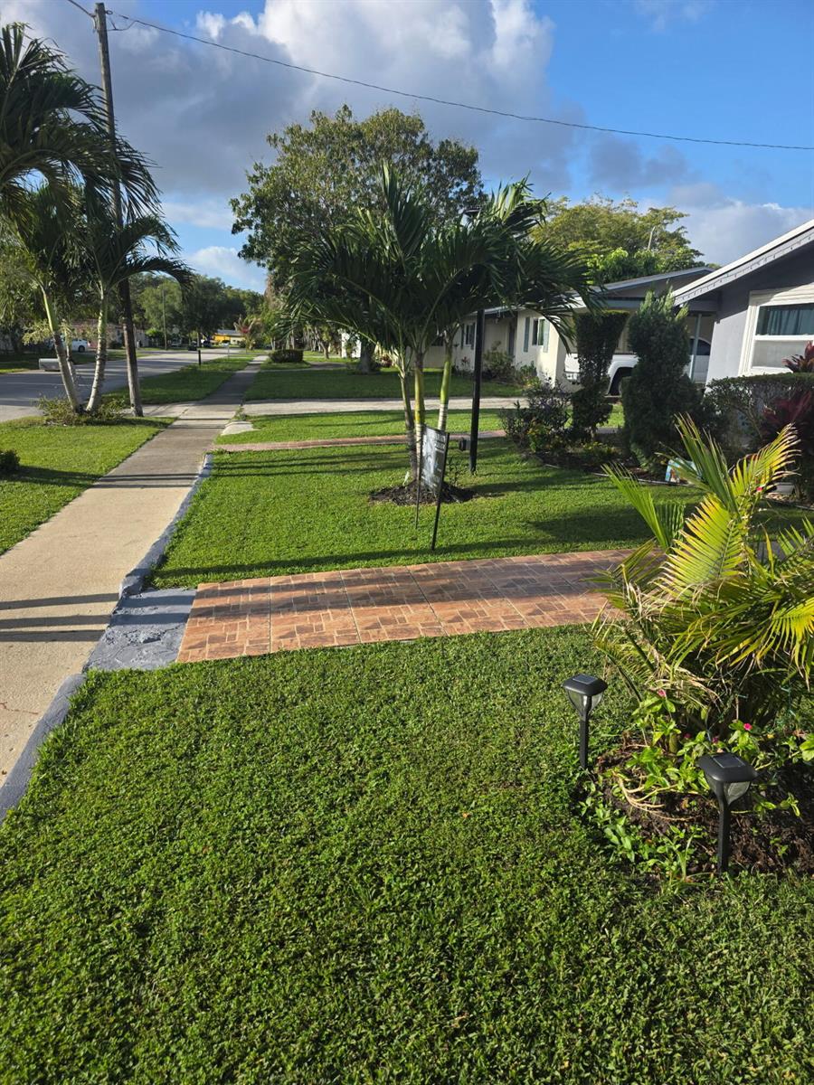 A front yard features a paved walkway, a palm tree, and a manicured lawn — 621 SW 56th Avenue, Margate FL 33068, MARGATE, FL