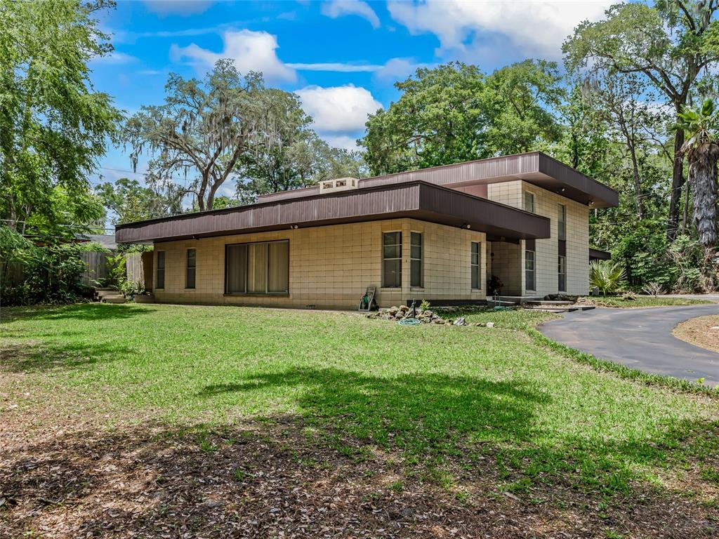 A two-story mid-century modern house with a flat roof and light-colored concrete block exterior — 2510 NW 30TH TERRACE, GAINESVILLE, FL