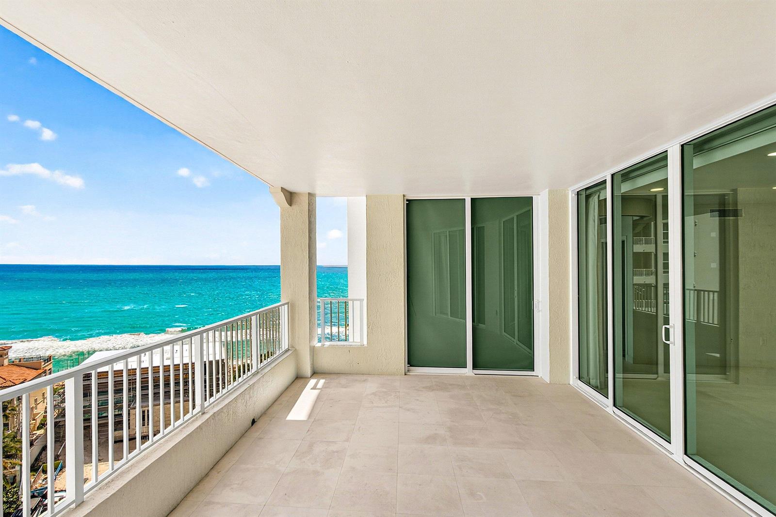 An elevator lobby features two white doors, a modern chandelier, and a decorative wall light — 3740 S Ocean Boulevard # 1102, Highland Beach FL 33487, HIGHLAND BEACH, FL