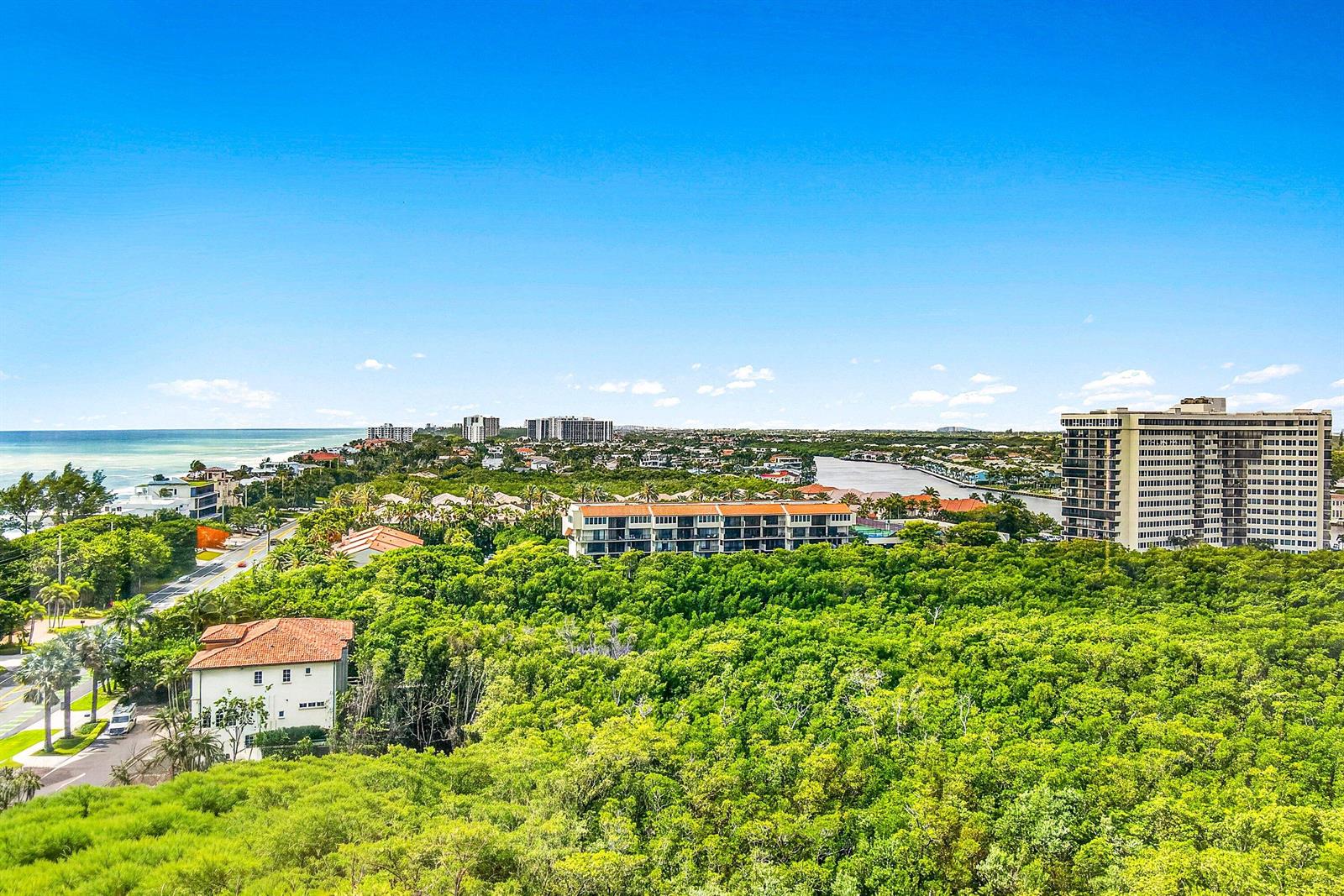 A modern kitchen features a marble waterfall island, stainless steel appliances, and a waterfront view — 3740 S Ocean Boulevard # 1102, Highland Beach FL 33487, HIGHLAND BEACH, FL