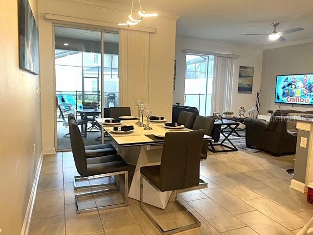 A dining area with a modern table and chairs sits adjacent to a living room — 4295 PARAGRAPH DRIVE, KISSIMMEE, FL