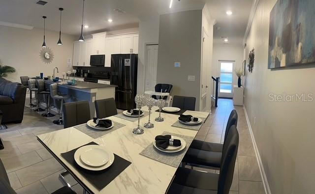 A dining area with a marble-topped table sits in front of an open-concept kitchen — 4295 PARAGRAPH DRIVE, KISSIMMEE, FL