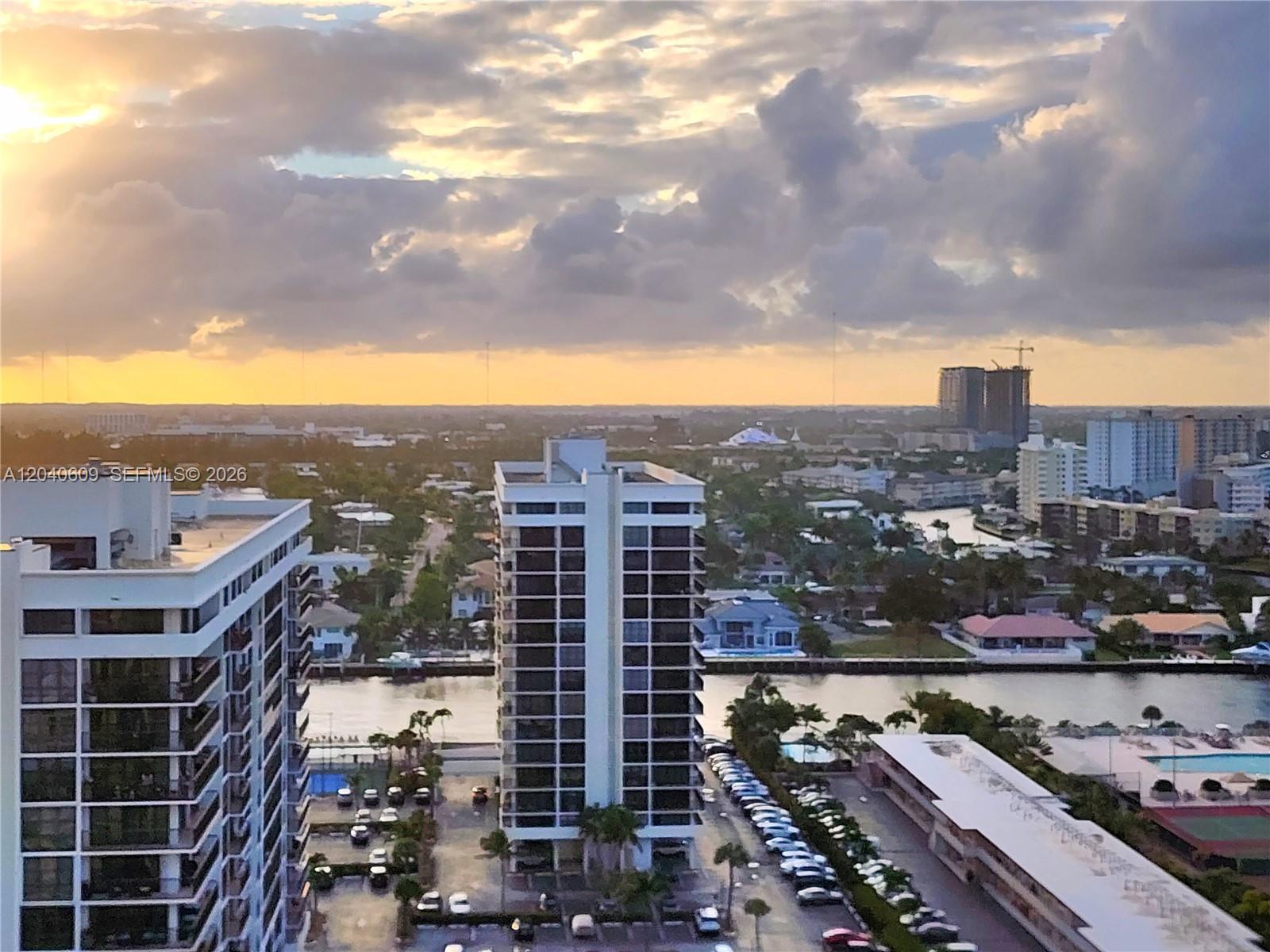 An elevated view shows high-rise apartment buildings, a canal, and a parking lot at sunset — 2030 S Ocean Dr # 1901, Hallandale Beach FL 33009, HALLANDALE BEACH, FL