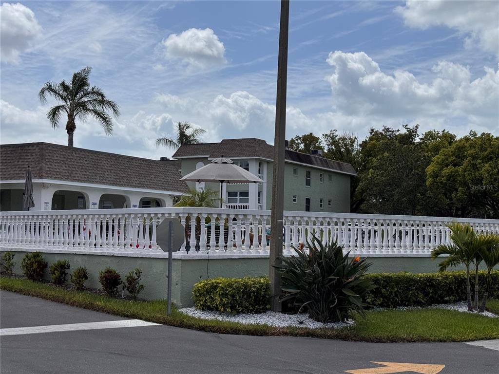 A white balustrade fence surrounds a pool area in front of a multi-story building — 1250 S PINELLAS AVENUE UNIT 804, TARPON SPRINGS, FL