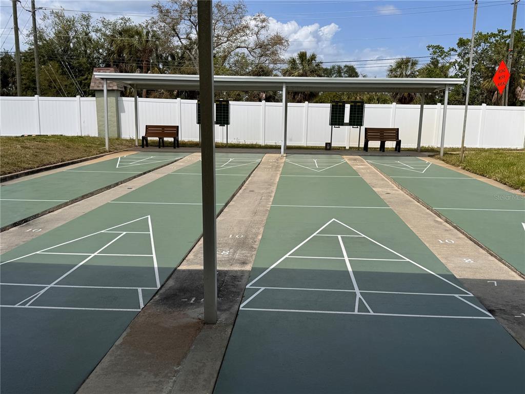 Two outdoor shuffleboard courts are situated under a covered pavilion with benches and scoreboards — 1250 S PINELLAS AVENUE UNIT 804, TARPON SPRINGS, FL