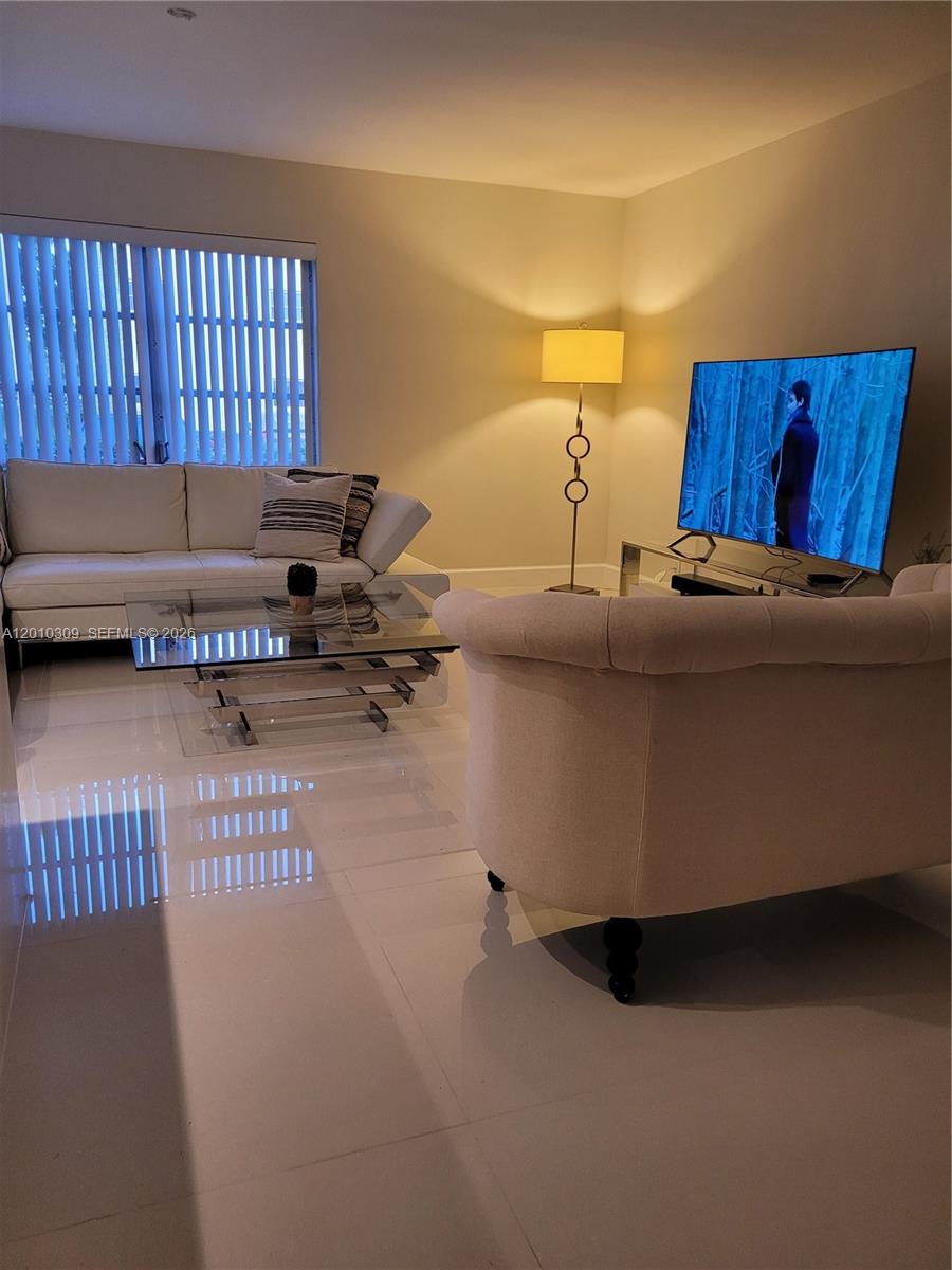 A living room features a white sofa, glass coffee table, armchair, and a television — 8101 SW 24th Ct # 108, Davie FL 33324, DAVIE, FL