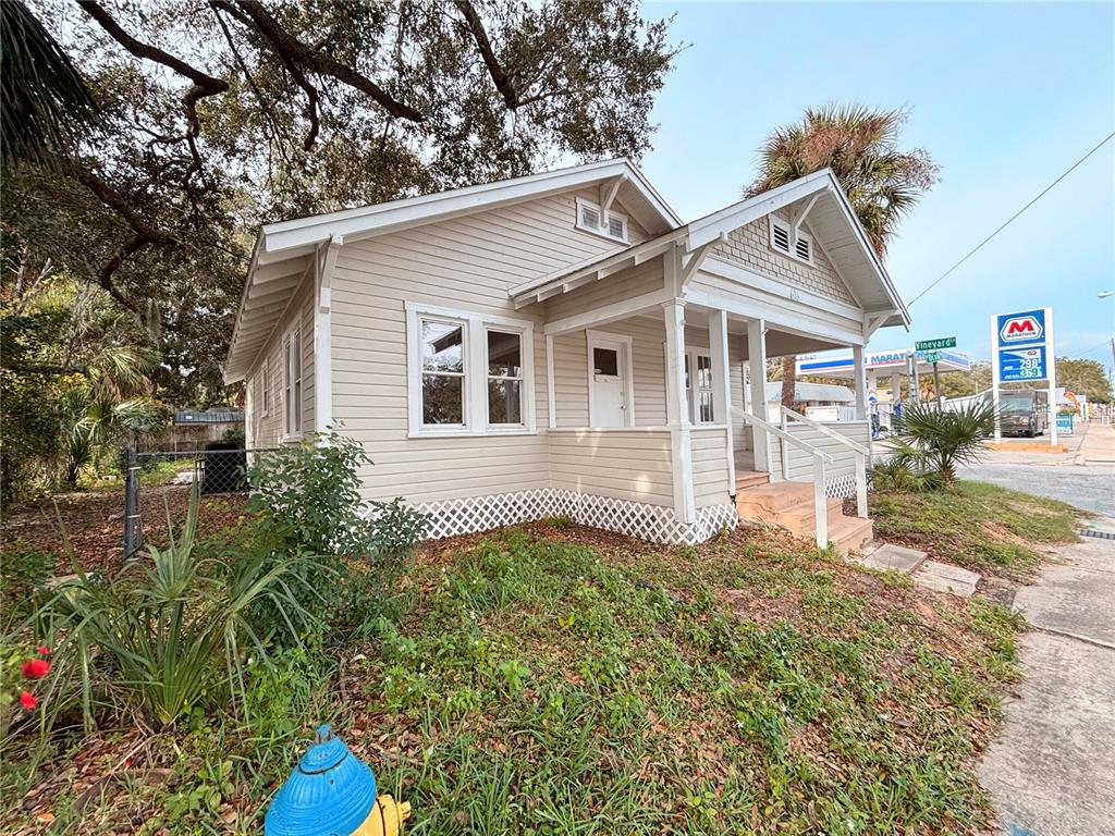 A beige, single-story house with a front porch and a blue fire hydrant in front — 616 N DIXIE FREEWAY, NEW SMYRNA BEACH, FL