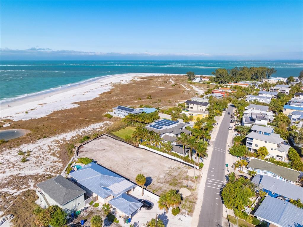 An aerial view shows a coastal neighborhood with a vacant lot near the beach — 769 N SHORE DRIVE, ANNA MARIA, FL