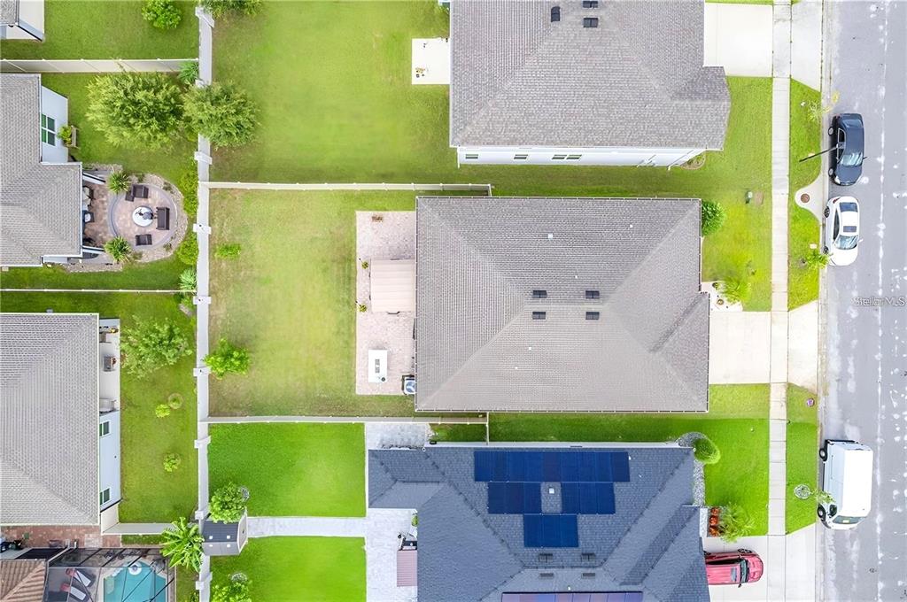 An aerial view shows a residential house with a fenced backyard and a paved patio — 13941 RUSHING CREEK RUN, ORLANDO, FL