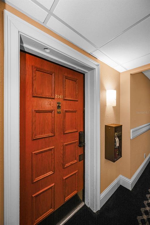 A wooden door with the number 2148 is set in a hallway with a fire extinguisher — 36750 US HIGHWAY 19 N UNIT 5-104, PALM HARBOR, FL