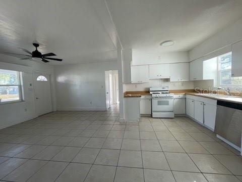 An open-concept kitchen and living area with white cabinets, tile flooring, and a ceiling fan — 331 51ST STREET COURT W, PALMETTO, FL
