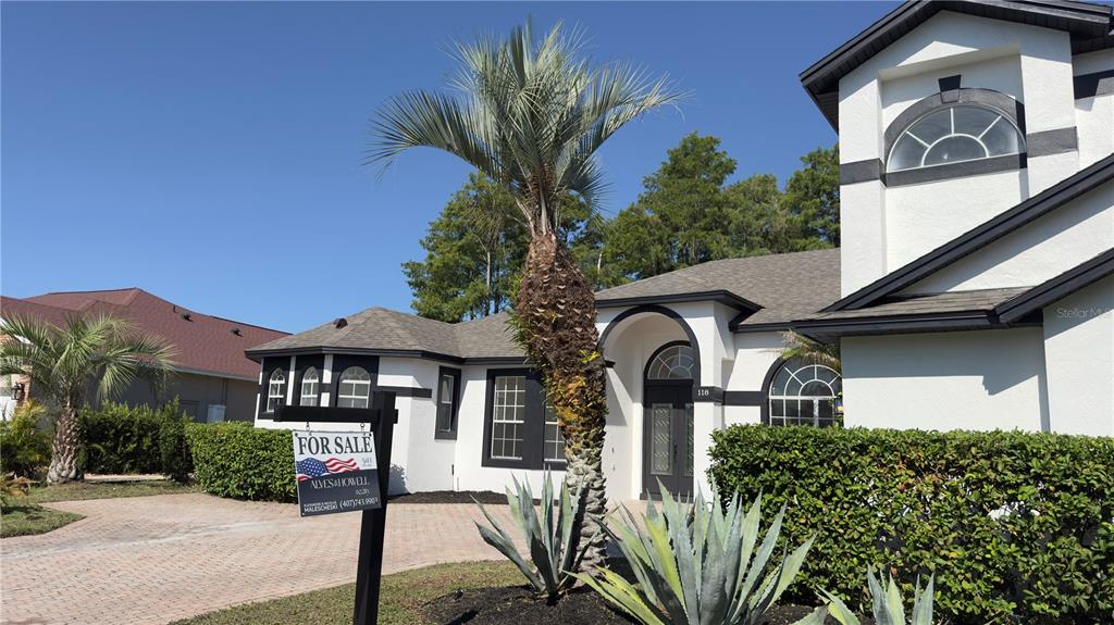 A white house with black trim and a palm tree in the front yard — 118 FAIRWAY POINTE CIRCLE, ORLANDO, FL