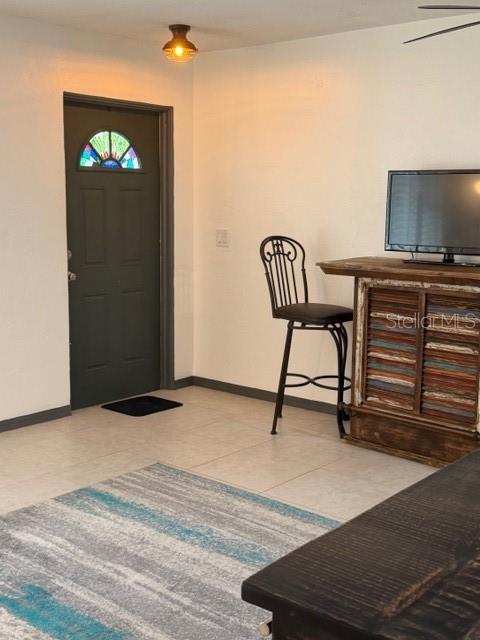 A room features a dark door with a stained-glass window, a bar stool, and television — 2020 WORLD PARKWAY BOULEVARD UNIT 10, CLEARWATER, FL