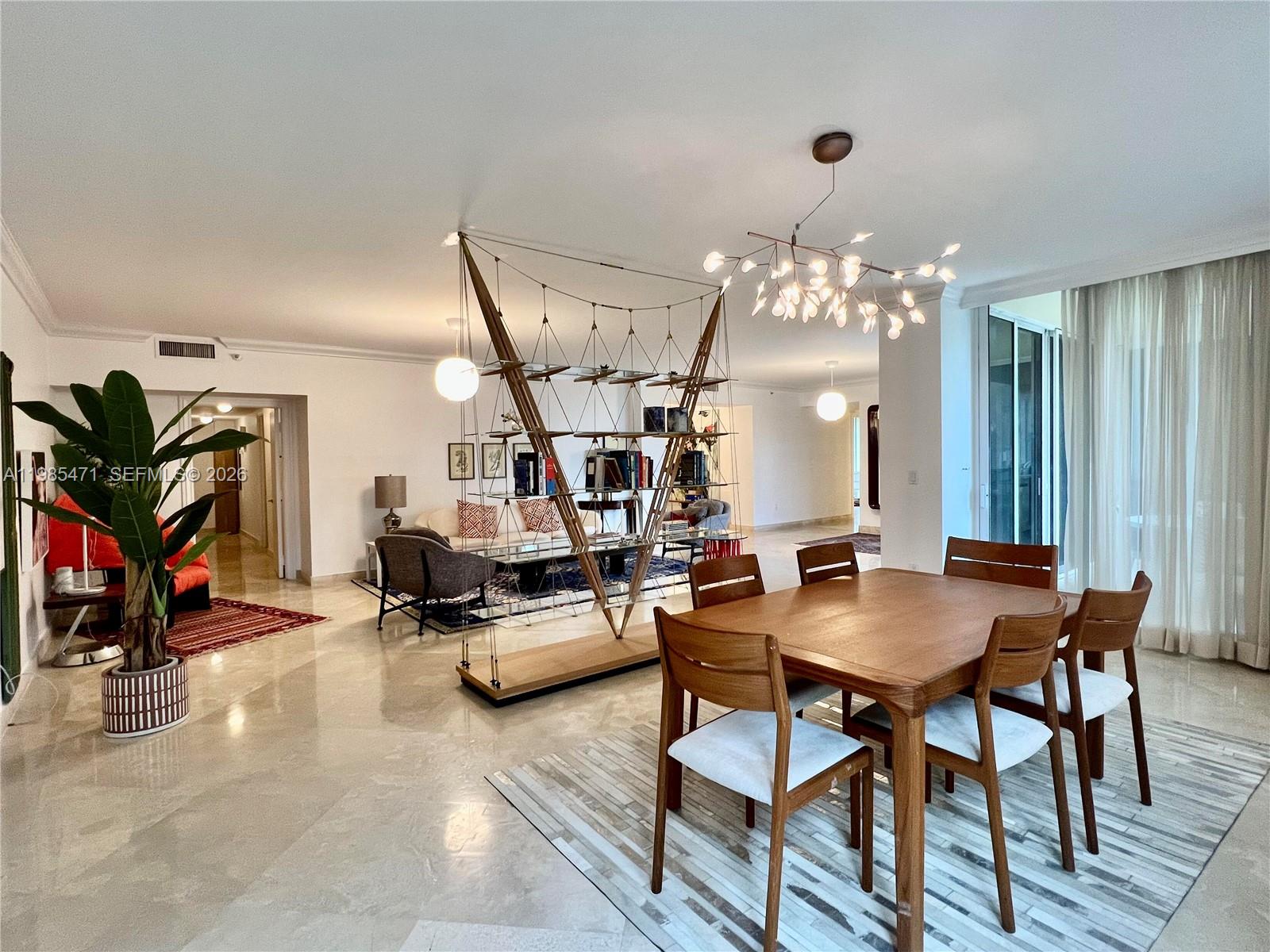 A dining area with a wooden table and chairs sits before a modern room divider — 445 Grand Bay Dr # 310, Key Biscayne FL 33149, KEY BISCAYNE, FL