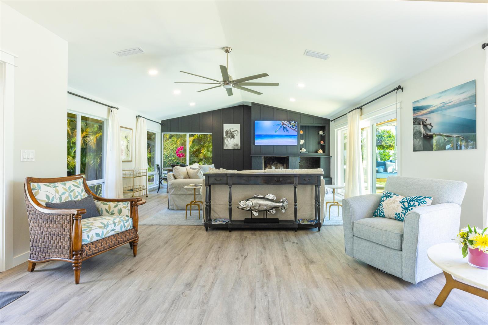 A bright living room features a dark accent wall with a fireplace and television — 1967 NW Palmetto Terrace, Stuart FL 34994, STUART, FL