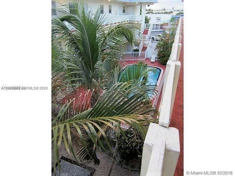 An elevated view shows a swimming pool surrounded by palm trees and a multi-story building — 12890 NE 8th Ave # 101, North Miami FL 33161, NORTH MIAMI, FL