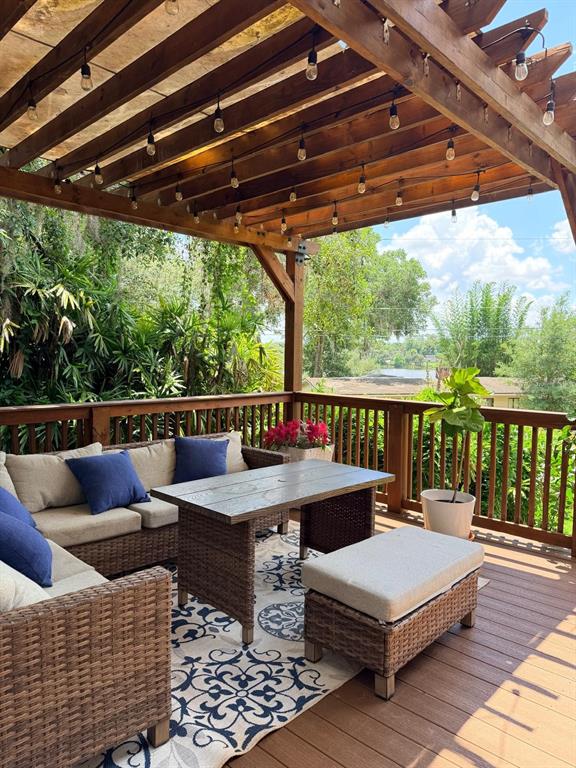 A wooden deck with a pergola and a two-story house with a balcony — 725 LAKE AVENUE, ALTAMONTE SPRINGS, FL