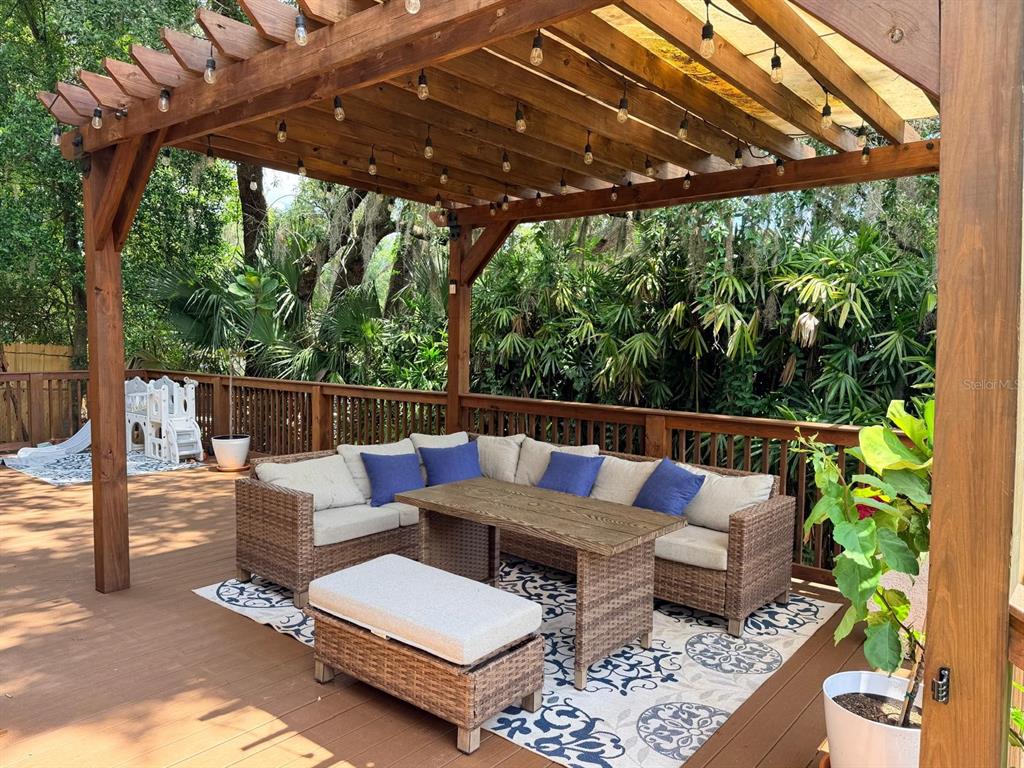 A living room features a brick fireplace, hardwood floors, and sliding glass doors to a deck — 725 LAKE AVENUE, ALTAMONTE SPRINGS, FL